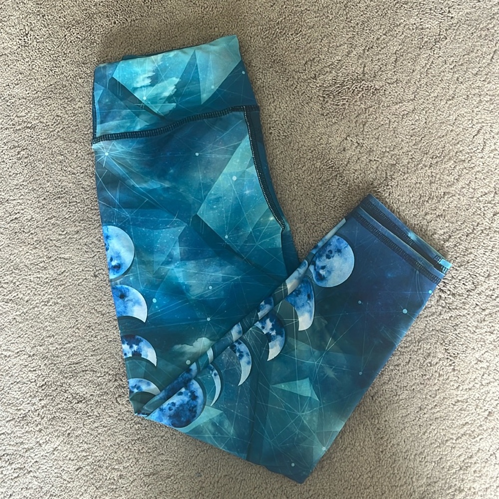 Differing shades of blue with different phases of the moon on the side of legs